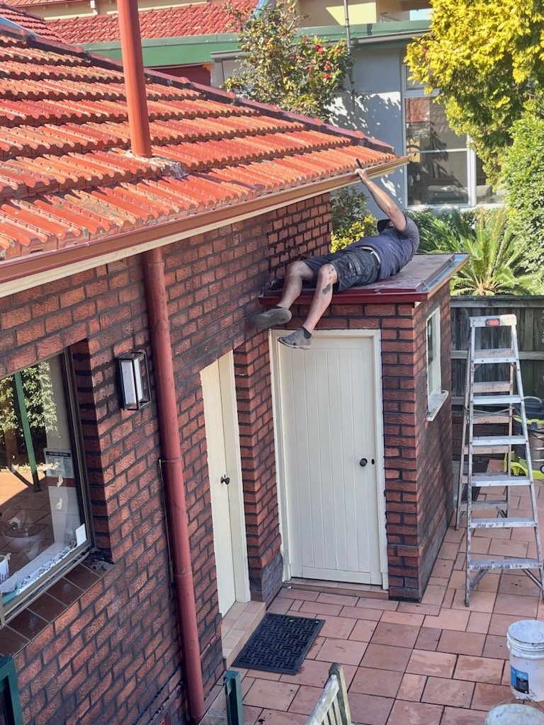 Tradesman repointing mortar joints on a brick home