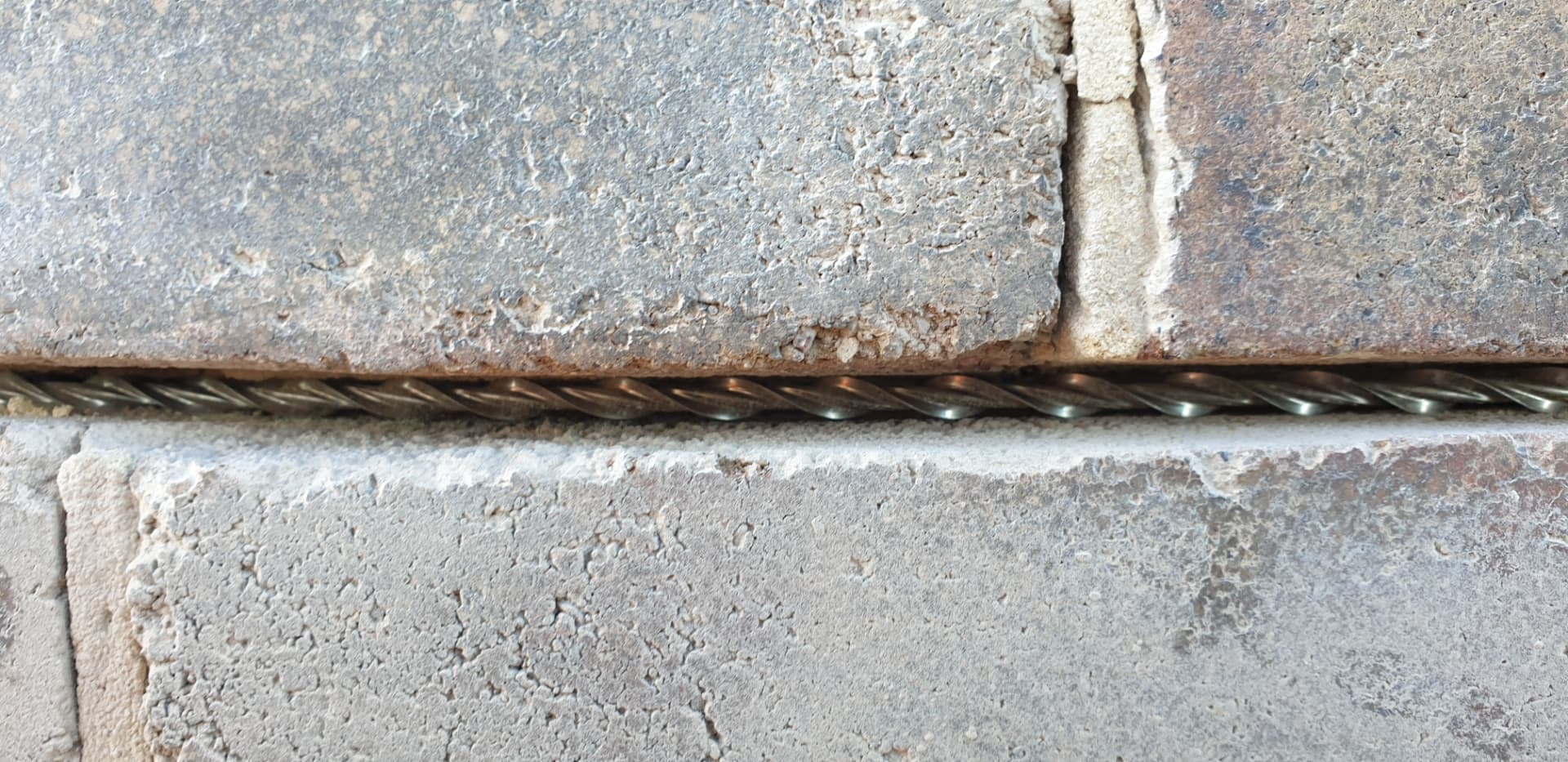 Stainless steel helical crack stitching bar installed into a bed joint