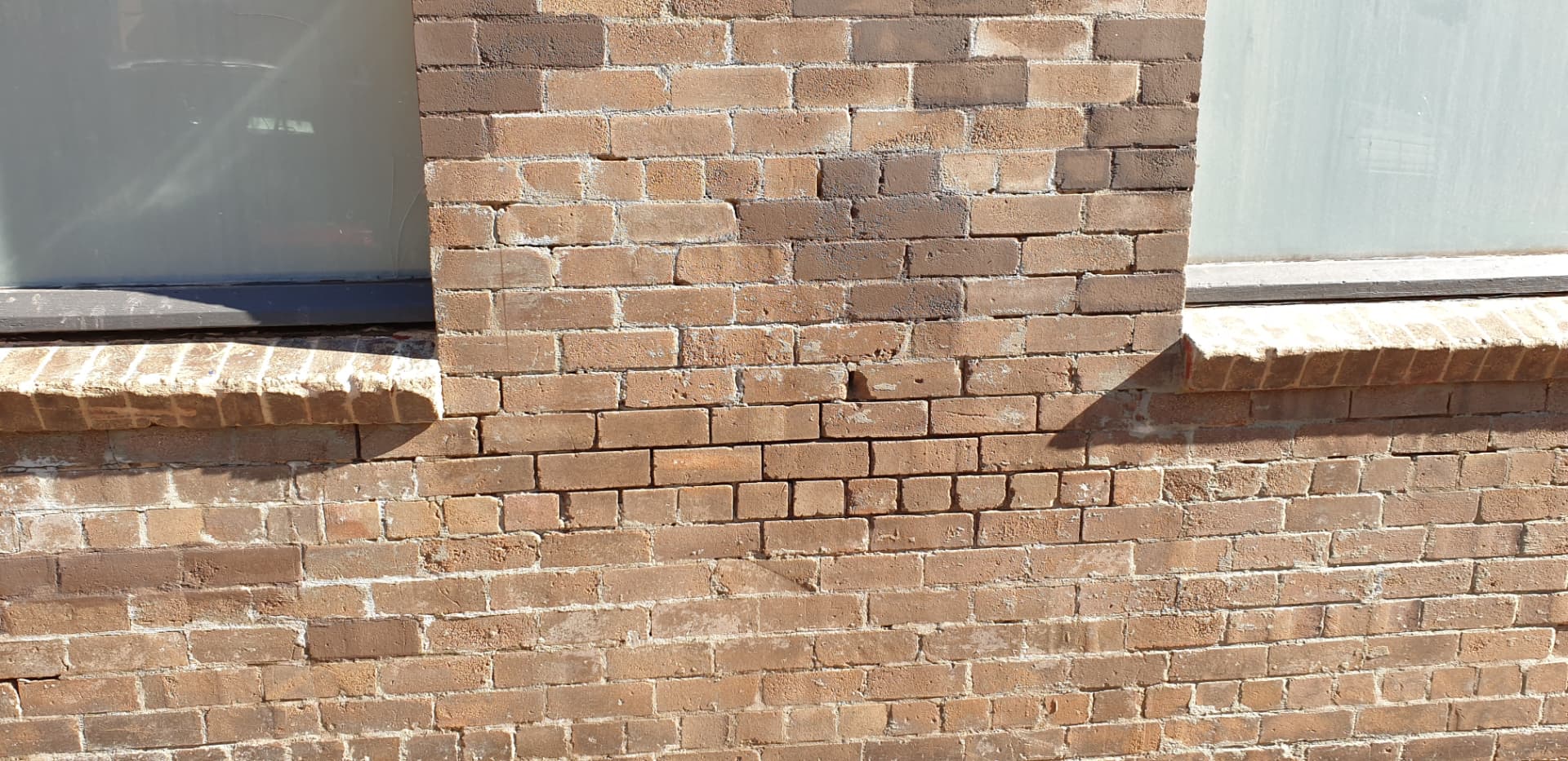 Brick wall with sections of mortar missing from the joints