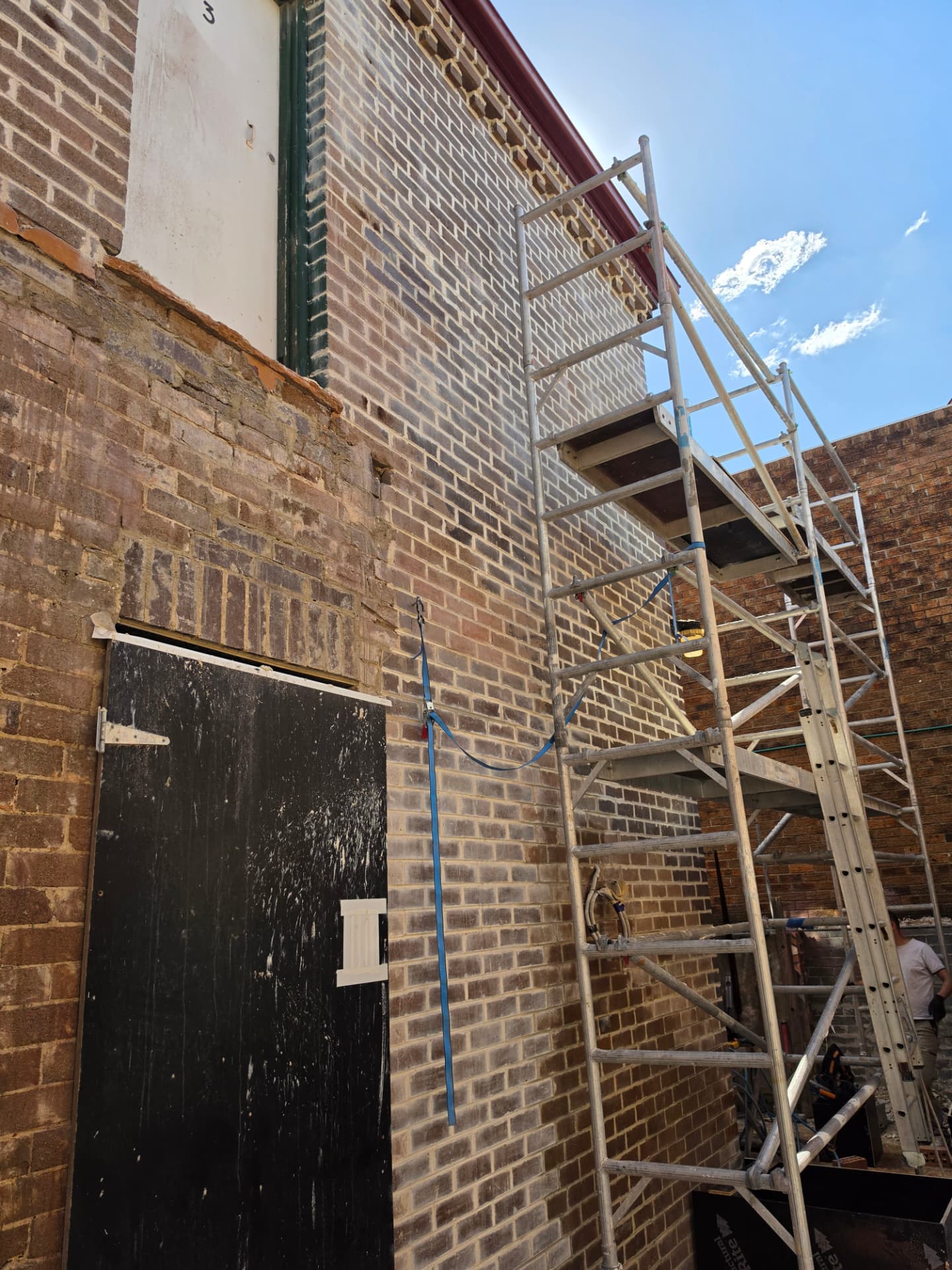 Repointed brick elevation viewed beside scaffolding