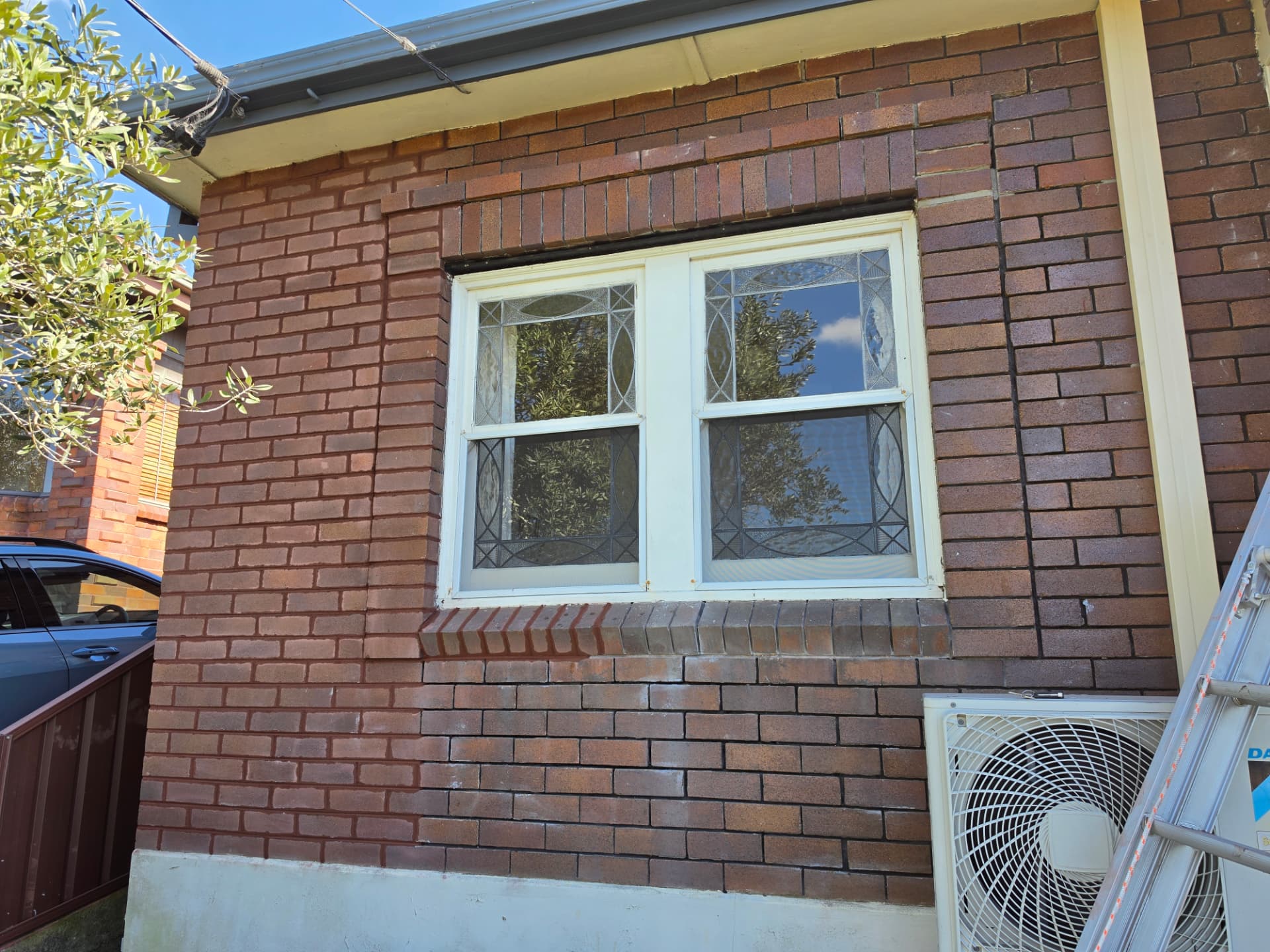 Repointed red brickwork surrounding a residential window